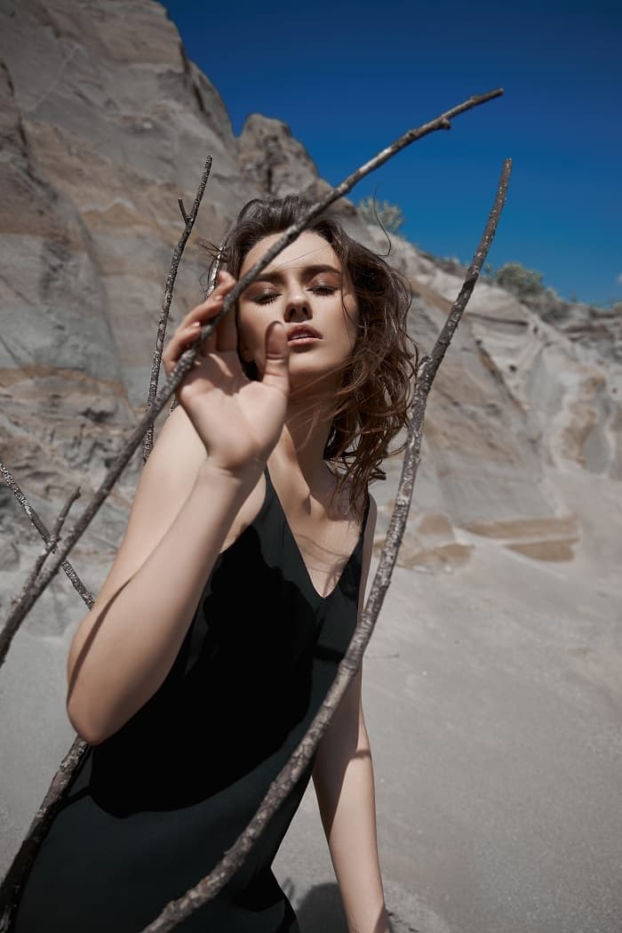 Woman posing with branches in desert